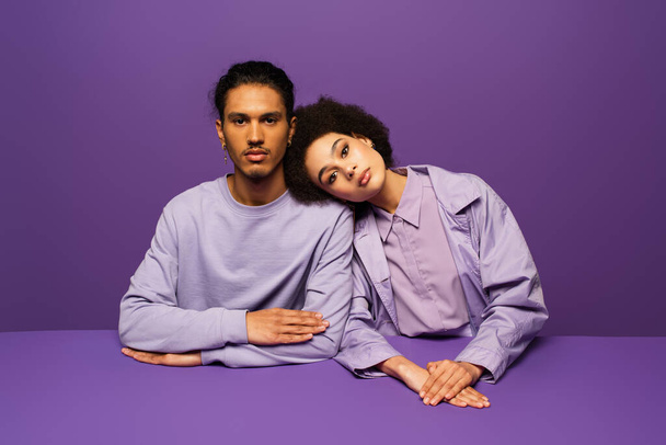 young african american woman leaning on man isolated on purple  - Photo, Image