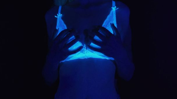 Photo of two women touching body in ultraviolet light - Photo, Image