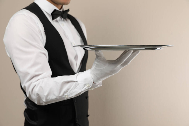 Butler with tray on beige background, closeup - Фото, зображення