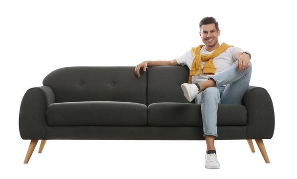 Man relaxing on comfortable grey sofa against white background - Φωτογραφία, εικόνα