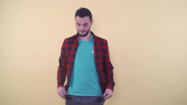 Verontruste man in casualclothes die lege zakken toont - Video