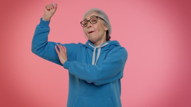 Idős nagymama nő mutatja bicepsz, látszó magabiztos érzés erő harcolni a jogokért - Felvétel, videó