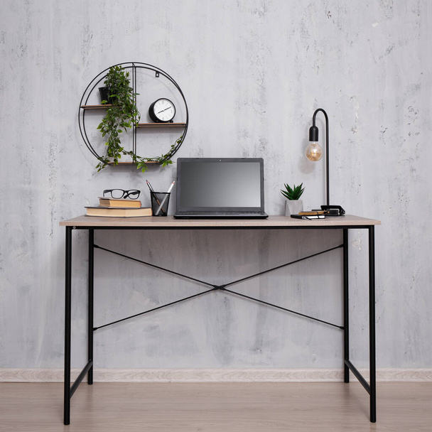 Moderne werkplek met laptop over betonnen muur op kantoor achtergrond - Foto, afbeelding