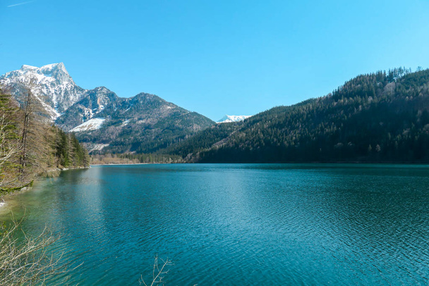 Avusturya 'daki Leopoldsteiner Gölü. Göl yüksek Alplerle çevrilidir. Sığ su kristal berraklığında, kaynak suyunun sakin bir yüzeyi var. Baharın başında. Sırtında buzul var. Sakinlik ve nostalji - Fotoğraf, Görsel