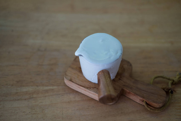 Χτυπημένη κρέμα γάλακτος σε μικρό γυάλινο κύπελλο έτοιμο να μαγειρέψει - Φωτογραφία, εικόνα