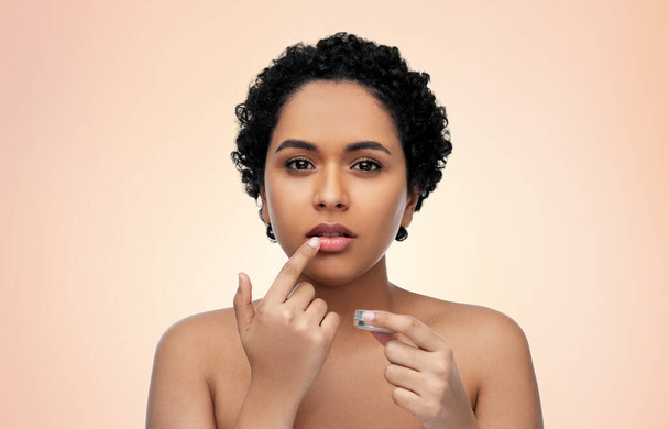 african american woman applying lip gloss - Photo, Image