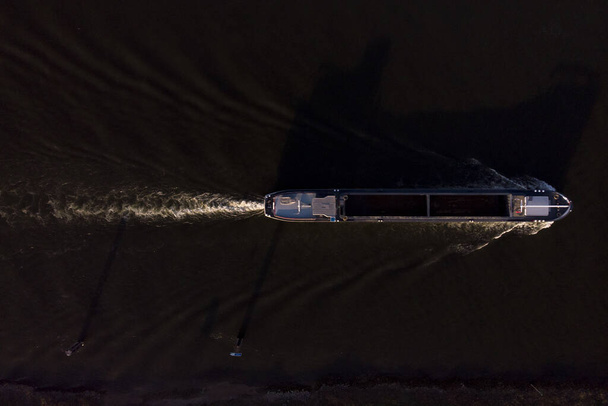 Graphic abstract minimalist top down aerial view of cargo ship leaving a trail in the river IJssel water - Valokuva, kuva