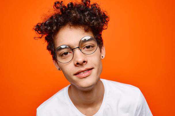 cute guy with curly hair wearing glasses white t-shirt close-up - Fotografie, Obrázek