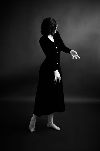 Fashionable and minimalistic portrait of brunette girl in  black dress. Grim studio portrait of  woman - Valokuva, kuva