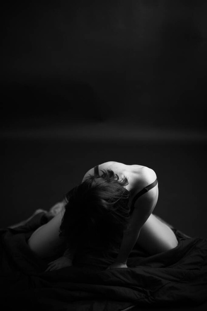Art portrait of girl in black bodysuit. Dancer in swimsuit on dark background. - 写真・画像