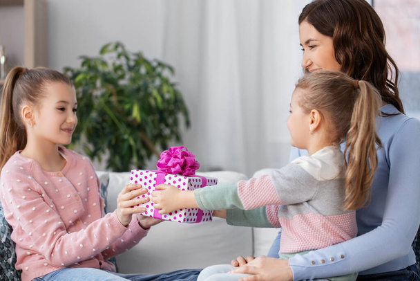 girl giving present to younger sister at home - Valokuva, kuva