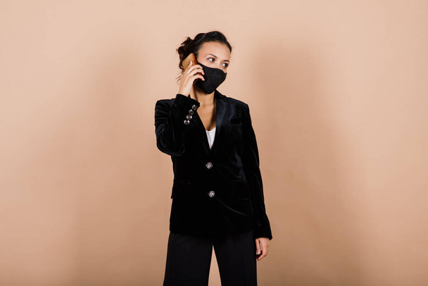 Retrato de una mujer de negocios negra con máscara facial durante una epidemia de virus en un estudio. - Foto, imagen