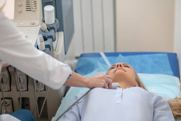 Doctor performing ultrasound examination of patients neck - Фото, изображение