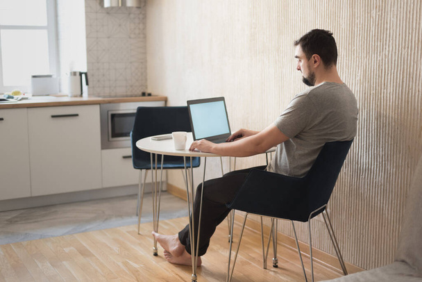 Jeune professionnel utilisant un ordinateur assis à la maison. Indépendant occupé travaillant à la maison. - Photo, image