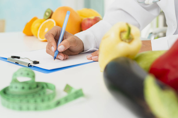 close up nutritionist writing prescription. Resolution and high quality beautiful photo - Foto, imagen
