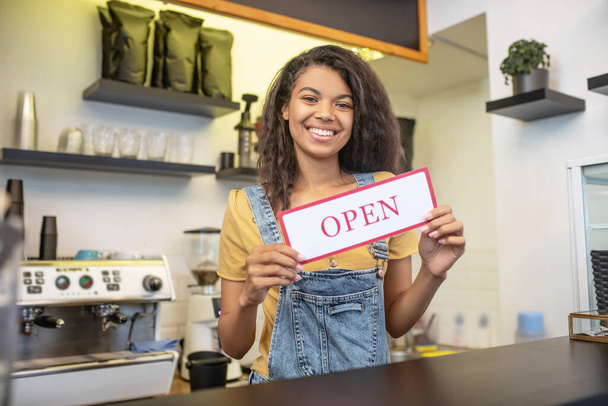 Woman at bar counter with sign that says open - Foto, immagini