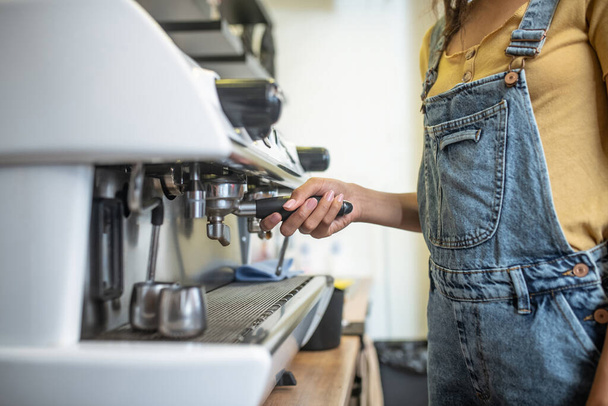 Female hand holding lever of coffee machine - Photo, image