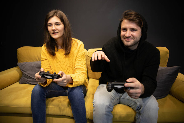 Soirée divertissement familial. souriant désinvolte habillé couple jouer jeu vidéo - Photo, image