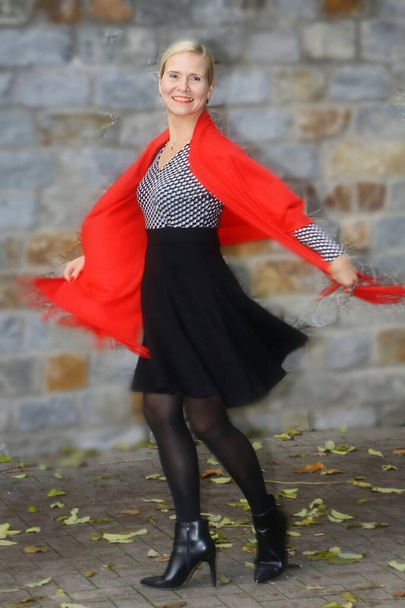 aantrekkelijke vrouw, modieus gekleed met rode sjaal, neemt swing voor een beurt, - Foto, afbeelding