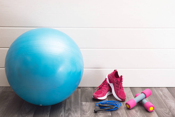 home sports - pink sneakers, dumbbells, jump rope, blue ball on a white background - Photo, image