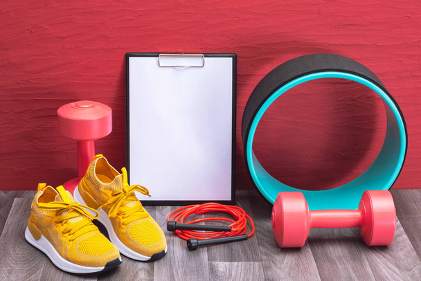 red dumbbells, jump rope and yellow sneakers, note board and massage roller - we train at home - Fotoğraf, Görsel