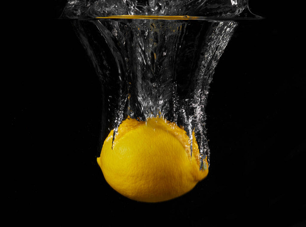 Sitruuna roiskeita veteen mustalla pohjalla - Valokuva, kuva