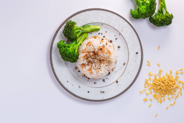 Rice with barley noodles and fresh broccoli on the plate. - Fotografie, Obrázek