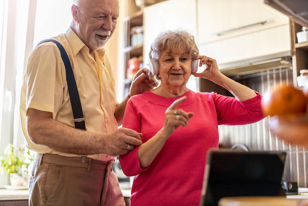 Happy senior couple using digital tablet at home - Фото, изображение