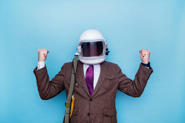 Empresario con casco de astronauta celebrando eufórico levantamiento de puños - Foto, Imagen