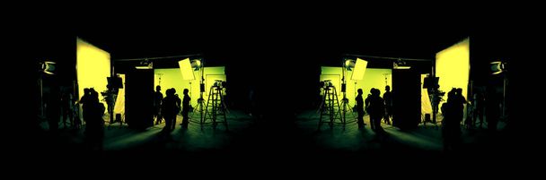 Silhouette images of film production. behind the scenes or b-roll of making video commercial movie. Film crew lightman and cameraman working together with film director in studio. Film industry. - Photo, image
