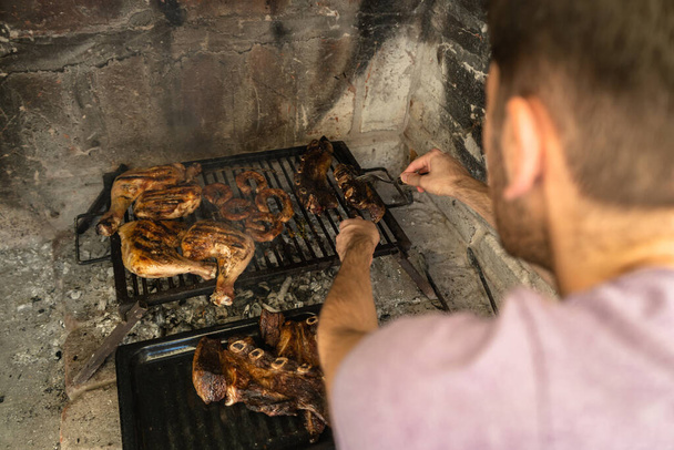 Hombre sirviendo carne a la parrilla listo para comer. Concepto de asado en Argentina. - Foto, Imagen