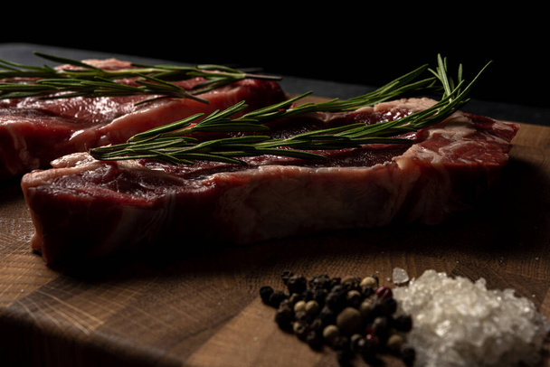 Raw marbled beef steak on a wooden cutting board - 写真・画像