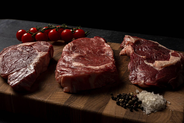 Raw marbled beef steak on a wooden cutting board - Foto, Imagen