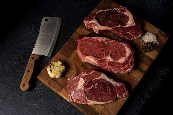 Raw marbled beef steak on a wooden cutting board - Fotó, kép