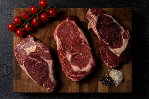 Raw marbled beef steak on a wooden cutting board - Foto, Bild