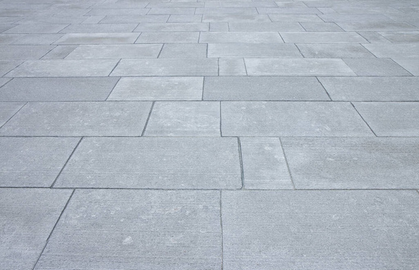 Nieuwe bestrating gemaakt met stenen blokken van rechthoekige vorm in een voetgangerszone. - Foto, afbeelding