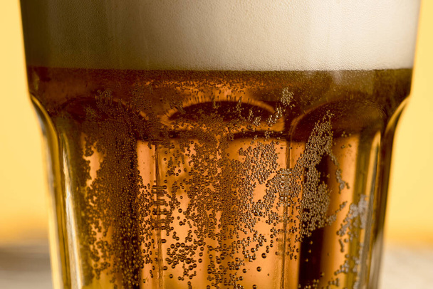 Крупным планом стекло холодное пиво с золотым пузырём. разрешение и высокое качество красивой фотографии - Фото, изображение