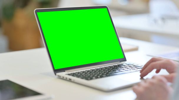 Jonge man met behulp van laptop met groene chroma scherm  - Foto, afbeelding