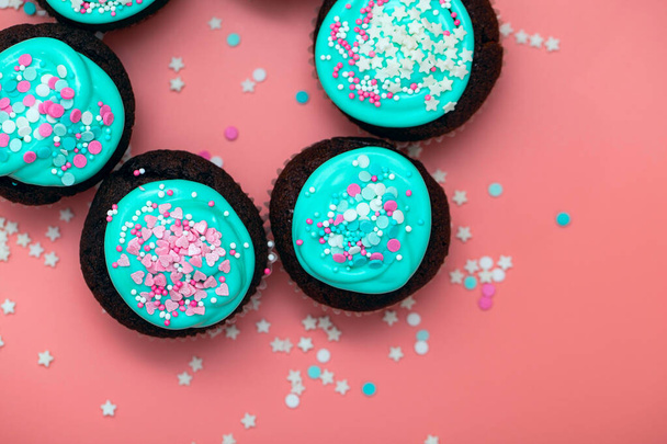 Lekker feestmaal. Cupcakes met glazuur en suikerhagelslag in de vorm van harten en sterren. Bovenaanzicht - Foto, afbeelding