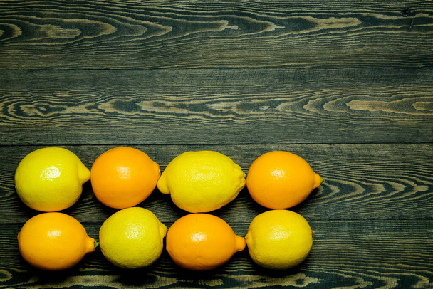 Limoni maturi su uno sfondo di legno fotografato dall'alto sotto forma di cornice - Foto, immagini