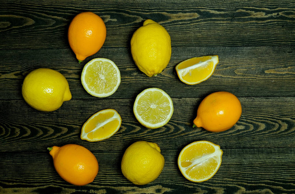 Limones enteros y medio limones sobre un fondo de madera oscura - Foto, imagen