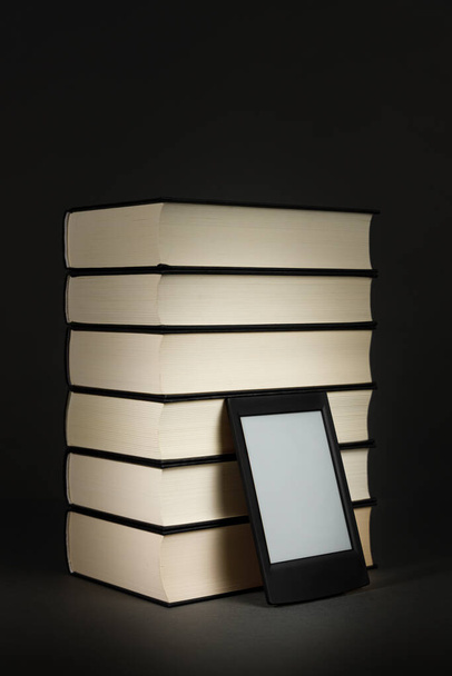 Современная электронная книга рядом с кучей старых книг - Фото, изображение