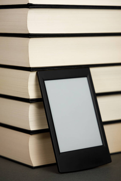Modern ebook next to a pile of old books - Photo, Image