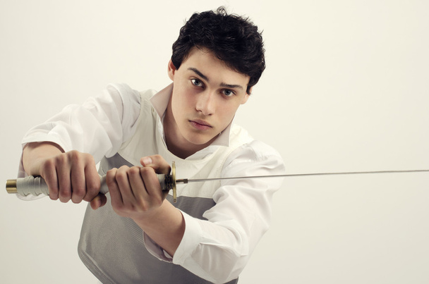 Man dressed in white holding a katana, Young beautiful boy learning to fight with a sword - 写真・画像