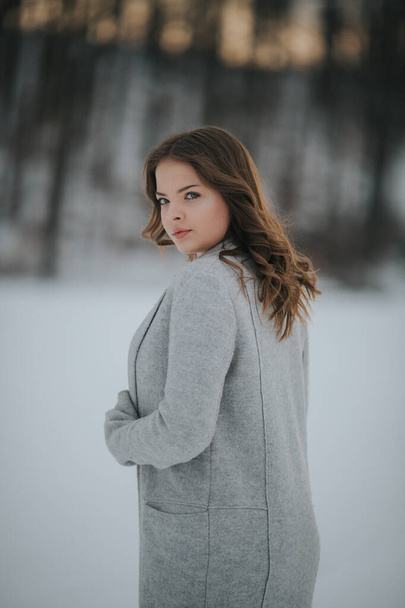 A beautiful female in a winter snowy forest - Φωτογραφία, εικόνα