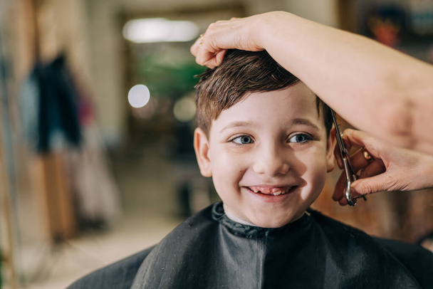 Haircut for little kid boy, professional barber doing haircut. Hairdress for children - Valokuva, kuva