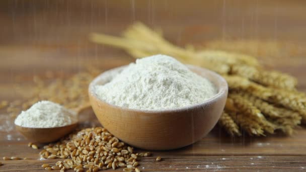 Farina di grano, chicchi di grano e spighe su un tavolo di legno. Setacciare la farina.  - Filmati, video