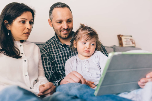 Famiglia felice al coperto a casa utilizzando tablet insieme - Foto, immagini