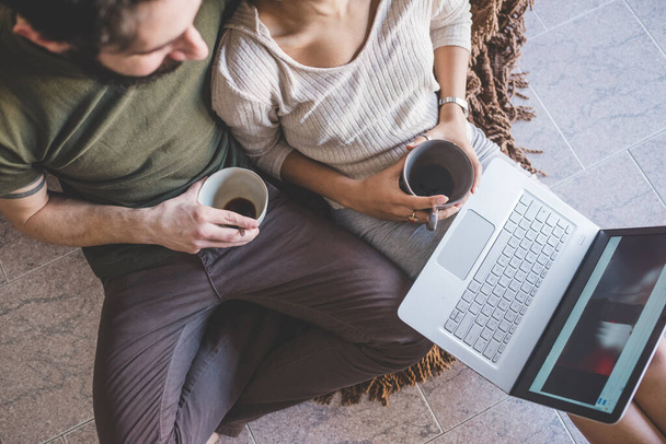 Junges multiethnisches Paar mit PC beim Kaffee - Foto, Bild