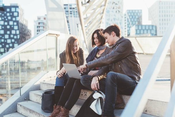 three people sitting outdoor using notebook - Photo, Image